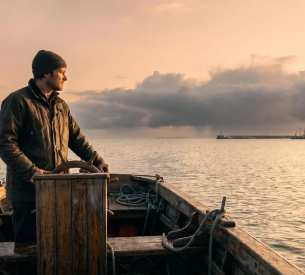Une personne pilote une petite embarcation entre des eaux calmes et un horizon orageux, symbolisant l'anticipation de la tresorerie sur 90 jours.
